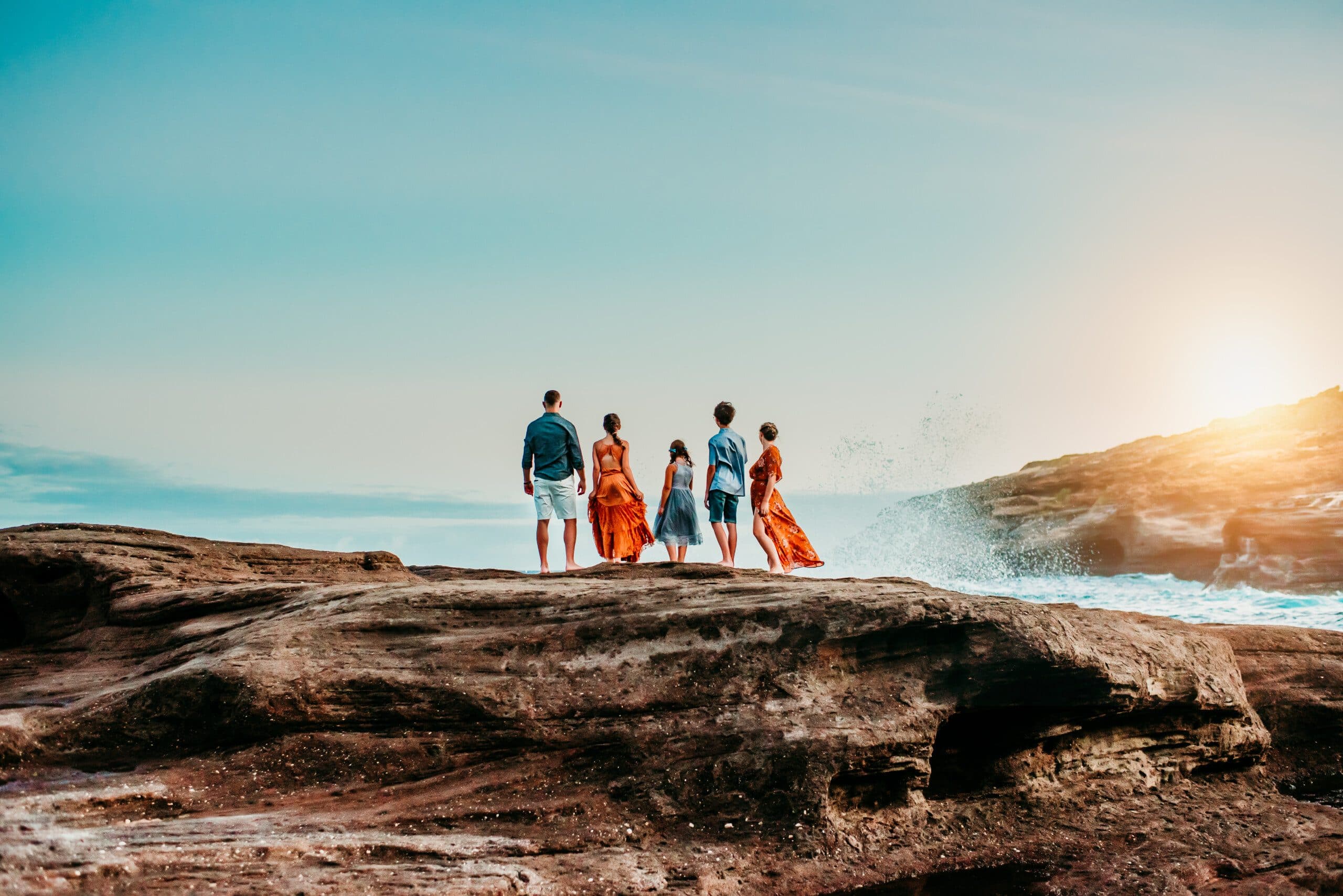 Jesica Allen and her family on the rocks by the ocean at sunset